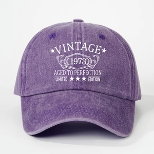 Close-up of VINTAGE 1973 print and washed purple fabric texture on the baseball cap