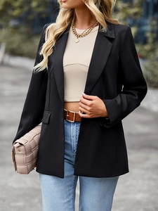 Outdoor street style view of a black casual short sleeve blazer with patchwork design
