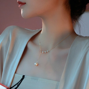 Detailed view of the 14k gold chain necklace with a Y-shaped drop baroque pearl design