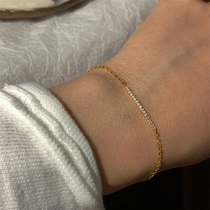 Close-up of minimalist gold chain bracelet featuring a row of sparkling white zircons