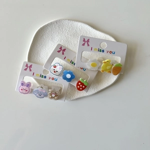 Close-up of set of 3 cartoon earrings including duck and carrot on display card