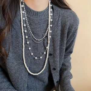 Close-up of elegant multi-layered pearl necklace with silver chain on a model