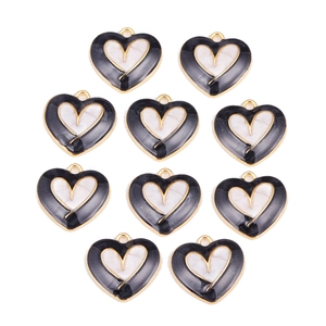 Detailed view of ten heart-shaped black and white enamel alloy pendants for DIY jewelry