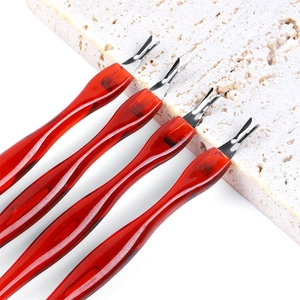 Close-up of four V-shaped leather groovers with amber resin handles on white stone