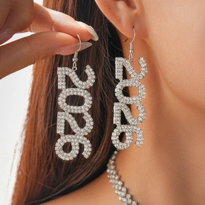 Close-up of sparkling 2026 number drop earrings with full rhinestone inlay on model