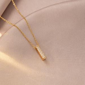 Macro detail of a gold bar pendant necklace with sparkling pavé cubic zirconia