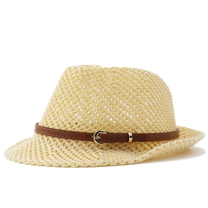 Detailed view of hollow-out straw hat with brown faux leather belt and gold buckle