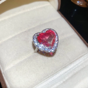 Macro detail of a sparkling pink heart-shaped zircon ring set in a velvet jewelry box