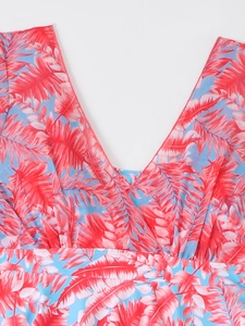 Detail of V-neckline and vibrant pink palm leaf print on tropical blue tankini top