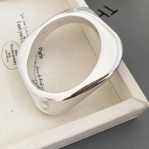 Macro shot of polished silver irregular geometric cuff bracelet with smooth minimalist finish