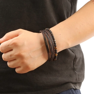 Detail of layered leather bracelets and natural stone beads on a male wrist