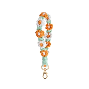 Handmade woven daisy flower phone wrist strap in orange and white with a gold metal clasp