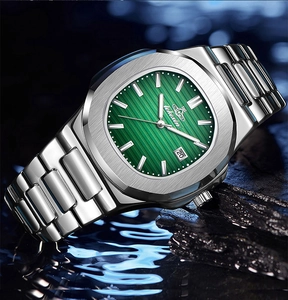 Detail of silver steel watch with green textured dial and calendar window on wet stones