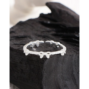 Elegant S925 sterling silver bow knot ring on charcoal background, minimalist jewelry