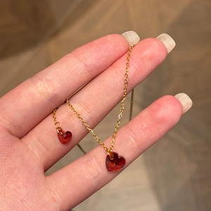 Golden necklace featuring a sparkling red heart pendant with high-quality cubic zirconia