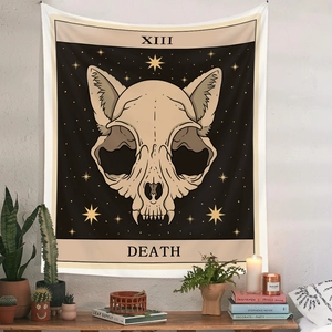 Detail of Bohemian tarot cat skull tapestry hanging above a desk with plants and candles