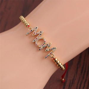 Detail view of MOM letter charm bracelet featuring micro-pave colored zircon on gold chain