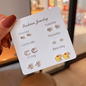 Detail view of 6-pair stud earring set with moon, star, and duck charms on weekly card