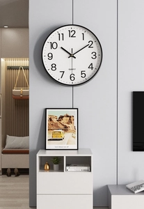 Detail view of a 30cm modern minimalist wall clock with black frame on a grey wall