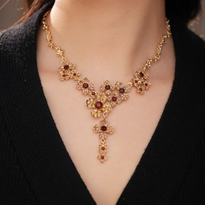 Close-up of vintage golden flower necklace with amber stones on a model wearing black