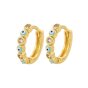 Detalle macro de pendientes de oro con motivos de ojo turco azul y circonitas