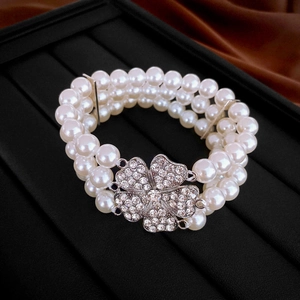 Bracelet élastique à trois rangs de perles avec fermoir fleur en strass argenté brillant