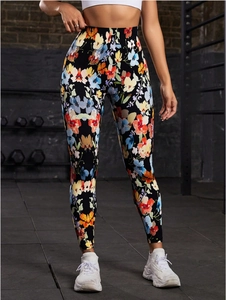 Close-up of high-waist yoga leggings with vibrant floral print on black fabric