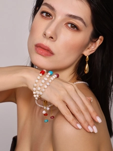 Gros plan d'un bracelet en perles d'eau douce à trois rangs avec perles colorées sur modèle
