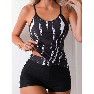 Detail of printed tankini swim top and black boyshorts with tie-dye patterns