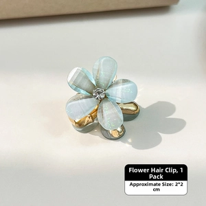 Detail of light blue floral hair claw clip with glitter petals and a center rhinestone