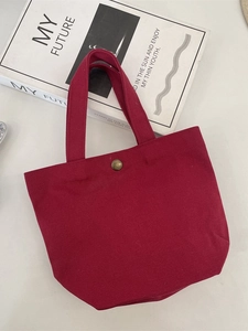 Minimalist burgundy canvas handbag with metal buckle and large capacity on white background
