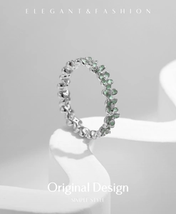 Macro shot of silver clover ring with mint green enamel petals and zircon stones
