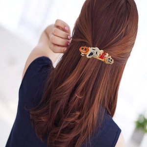Halloween pumpkin and skull hair clip with rhinestones worn on reddish-brown hair