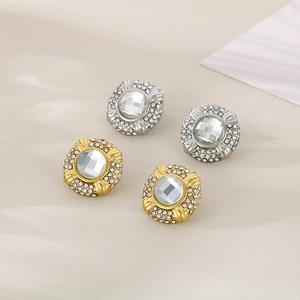 Macro shot of 18k gold and silver oval earrings with square cubic zirconia settings