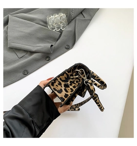 Close-up of leopard print mini crossbody bag with silver hardware and textured fabric