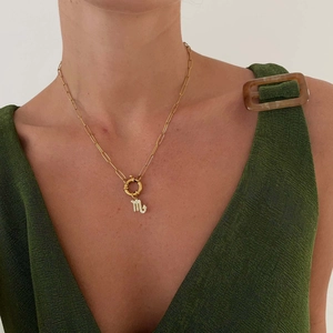 Close-up of Scorpio zodiac pendant on a golden paperclip link chain necklace
