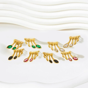 Macro detail of leaf-shaped gold earrings with colorful marquise-cut zircon stones