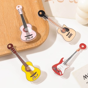 Close-up of colorful acrylic guitar-shaped hair clips in pink, beige, yellow, and red