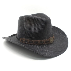 Detail of black woven straw cowboy hat featuring a brown band and metal star emblem