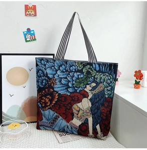 Detailed view of tapestry tote bag featuring floral jacquard art and striped straps