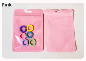 Detailed view of colorful plastic rings and pink matte ziplock bags with hanging holes