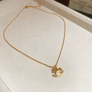 Golden rocking horse pendant necklace with bead chain in a velvet jewelry box