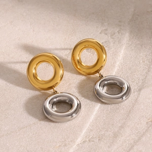 Macro shot of two-tone gold and silver interlocking circles on a textured stone surface