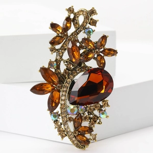 Close-up of vintage bronze alloy brooch with large pear-shaped brown crystals on white base