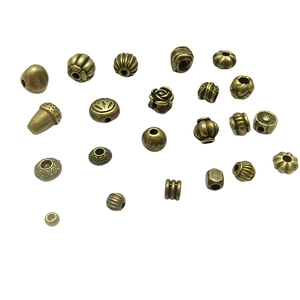 Assorted bronze alloy spacer beads for DIY jewelry making in various shapes on white background