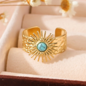 Adjustable gold hammered ring with turquoise stone and sunburst design on beige box