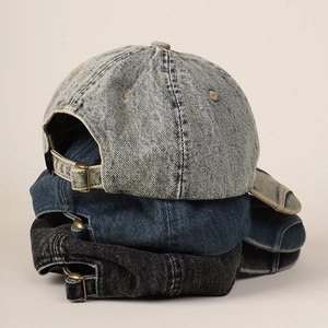 Detailed stack of vintage washed denim baseball caps in light blue, dark blue and grey