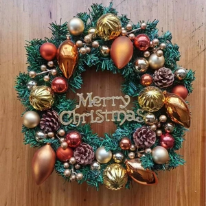 Christmas wreath with pine cones and colorful ornaments on a wooden background