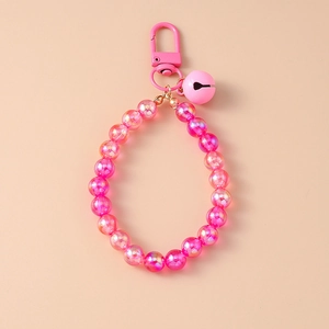 Detailed view of pink beaded wristlet strap with a matching bell and metal swivel clasp