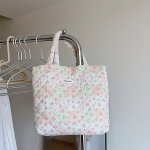 Detailed shot of pink floral quilted handbag hanging with a simple wish brand label